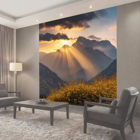 Фотообои Закат в горах, величественные вершины, окутанные облаками, золотистые лучи солнца пробиваются сквозь облака…